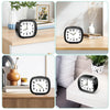 A black silent analog alarm clock with a luminous display is shown in various contexts on wooden surfaces.
