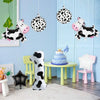 A party set featuring cow print balloons and a number balloon displayed in a nursery setting.