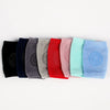 A row of colorful knitted knee pads for crawling infants in various shades of purple, blue, pink, and red.