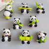 A collection of cute 3D panda fridge magnets in black and white with green accents.