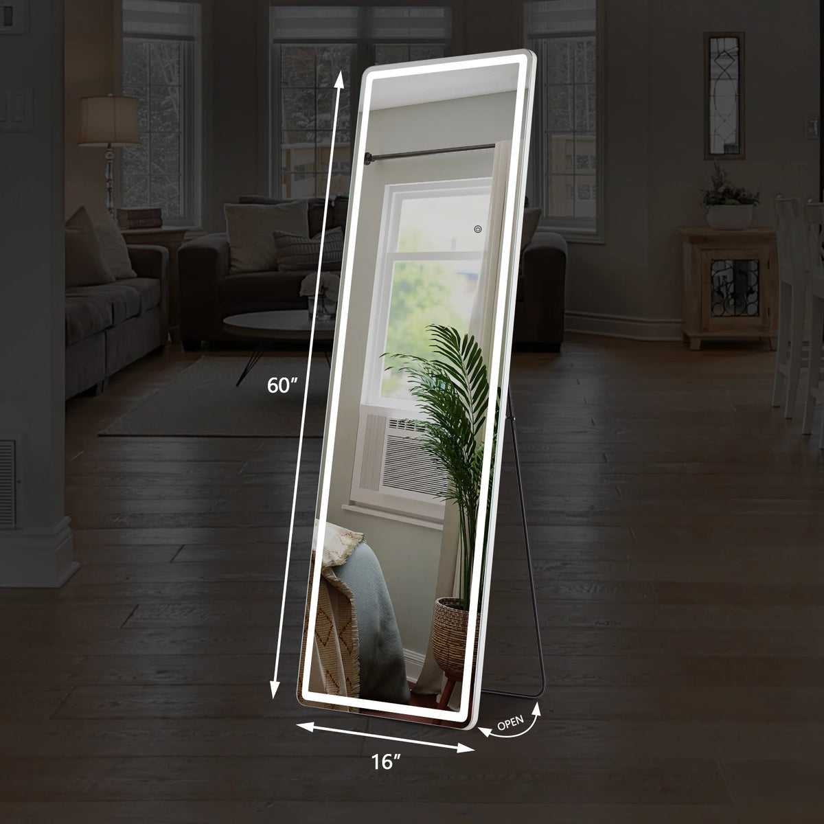A full-length LED floor mirror is shown in a living room, reflecting the interior and outdoor light.
