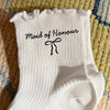 White knitted socks with black embroidery reading Maid of Honour