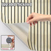 A hand is holding a roll of upgraded thickened wood grain wallpaper, showing the thickness measurement.