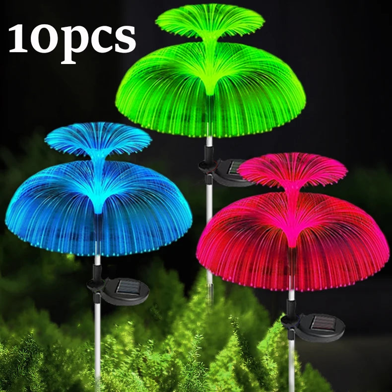 Ten solar jellyfish garden lights in green, blue, and red colors displayed against a green foliage background.