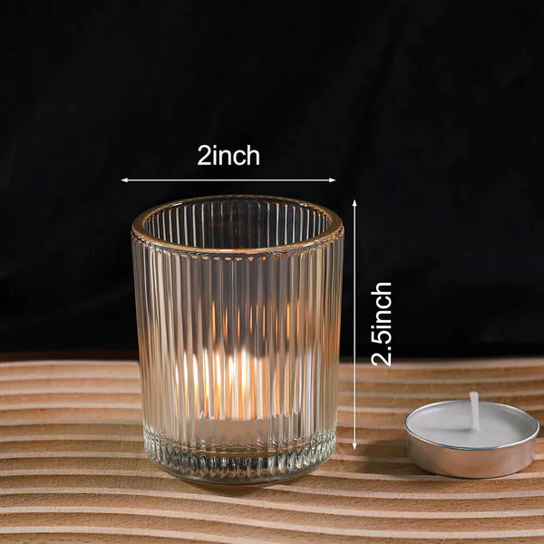 A clear glass votive candle holder with vertical ribbing, measuring 2 inches high.
