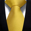 A close-up of a solid gold yellow silk necktie tied in a knot against a black suit jacket.