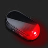 A sleek, oval red device with a silver casing is illuminated by a bright red glow on a dark background.
