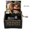 A wooden music box featuring a figurine of a man and woman, with a crank mechanism visible.