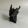 Figurine de dragon miniature noir pour bureau, avec des cornes pointues et une texture détaillée.