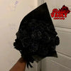 A bouquet of dark black glitter artificial roses is held up against a white background.