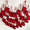 A string of red knitted socks shaped like letters of the alphabet for Christmas tree ornaments