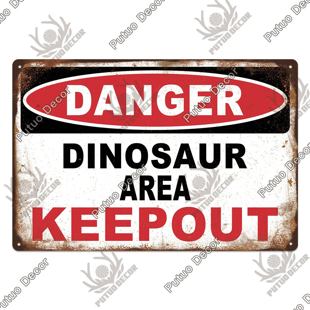 A vintage metal warning sign with red and white text that reads DANGER DINOSAUR AREA KEEPOUT