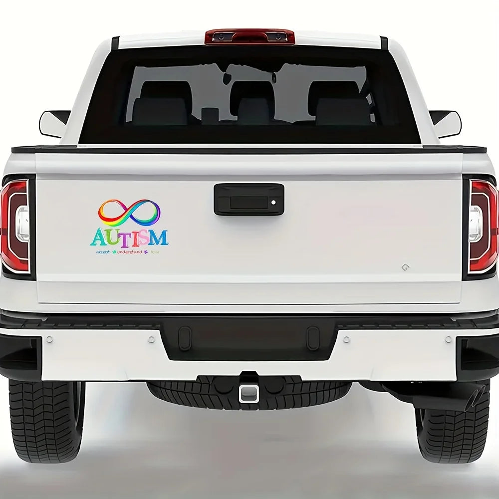Rear view of a white pickup truck with an Autism Awareness vinyl decal on the tailgate.