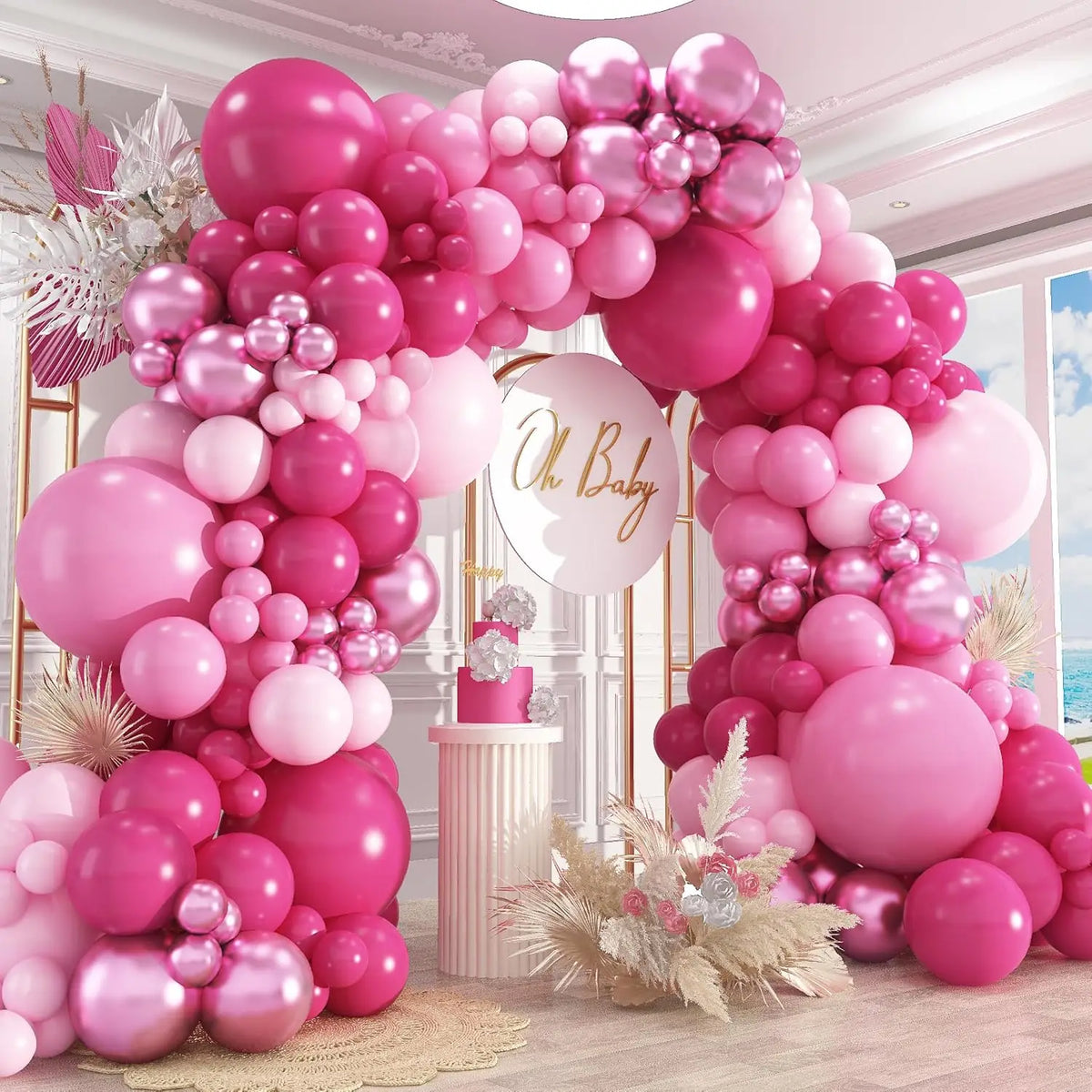 A pink and white balloon garland arch decorated with various sized balloons for a celebration.