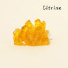 A cluster of bright yellow Citrine crystals displayed on a light background.