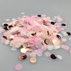 A pile of multicolor paper confetti consisting of pink, gold, and white circular pieces.
