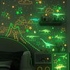 A green wall decorated with glow-in-the-dark dinosaur stickers and stars for a child's room.