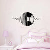 Black vinyl decal of a sound wave graphic on a white wall above a bed