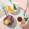 Ein Set aus drei duftenden Kerzen mit Zitrus-, Grün- und floralen Elementen in hellem Wachs.