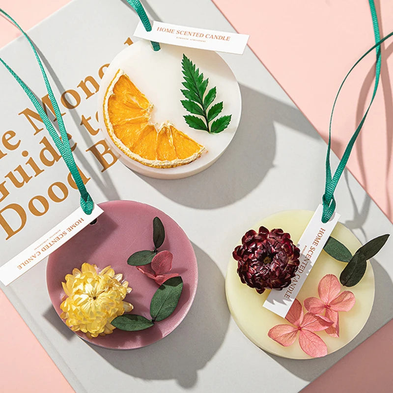 Ein Set aus drei duftenden Kerzen mit Zitrus-, Grün- und floralen Elementen in hellem Wachs.