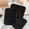 A black foldable vanity mirror with an adjustable stand and a separate compact mirror resting on a white surface.