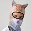 A person wearing a cat animal ski balaclava with orange and white striped fur pattern.