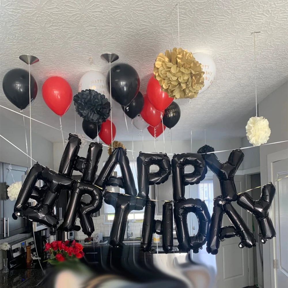 Black foil letter balloons spelling HAPPY BIRTHDAY hanging from the ceiling