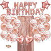 A set of rose gold foil balloons spelling out Happy Birthday with gold confetti stars and a wooden background.