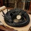 A black dragon design decorative tray holding a gold watch and jewelry on a wooden surface.