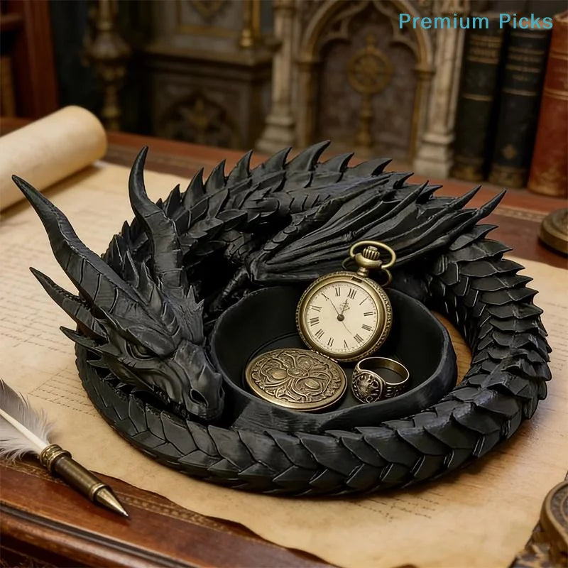 A black dragon design decorative tray holding a gold watch and jewelry on a wooden surface.