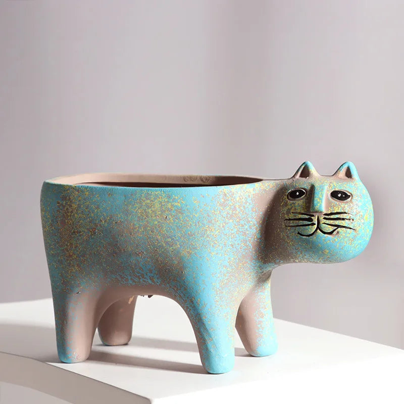 A ceramic succulent planter shaped like a cat with blue and gold speckled glaze.