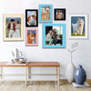 A collection of framed photos featuring people and pets displayed on a white wall.