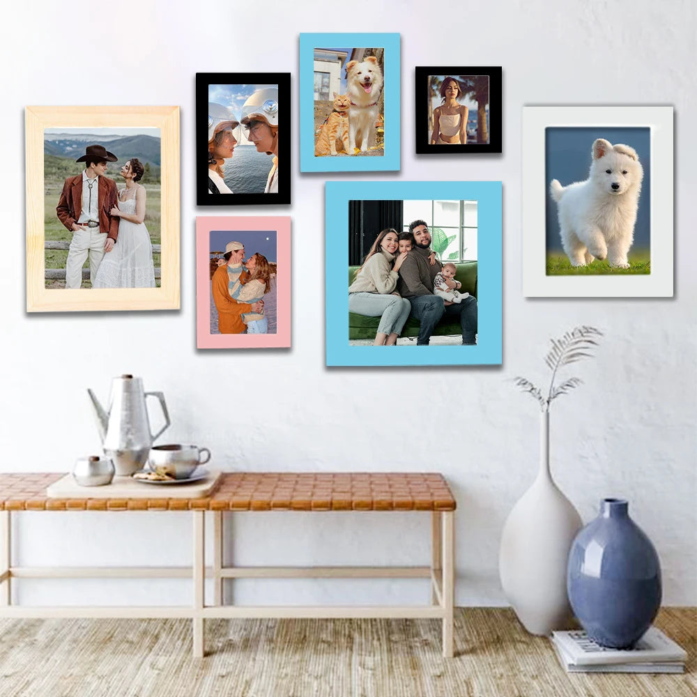 A collection of framed photos featuring people and pets displayed on a white wall.