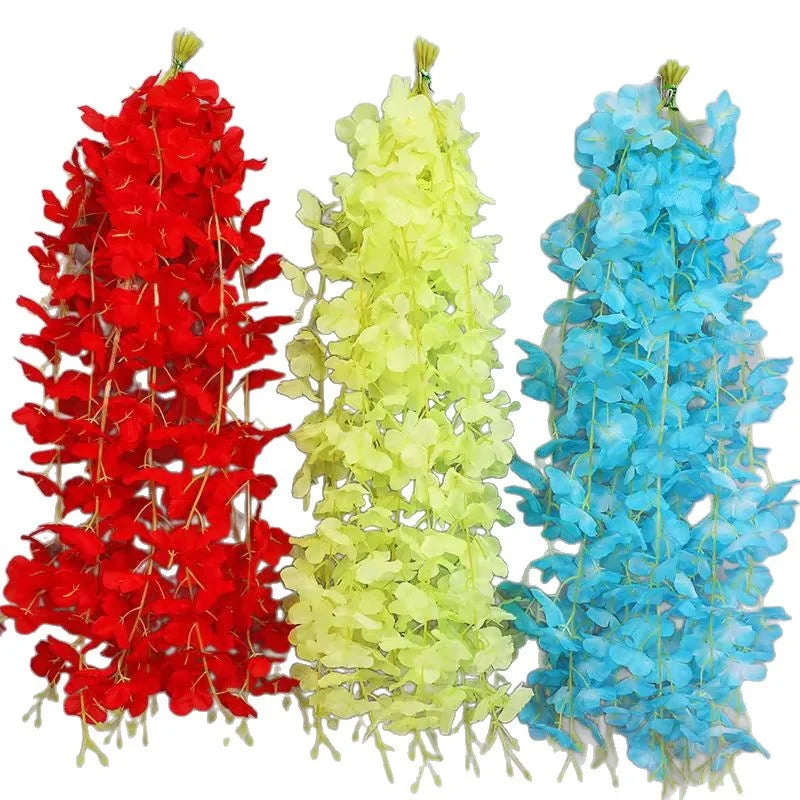 Three vertical garlands of artificial wisteria flowers in red, yellow, and blue.