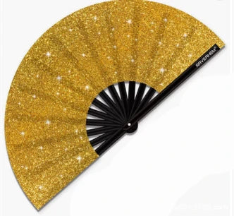 A golden glitter hand fan with a black handle and pleated fan blades.