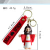 A red silicone keychain featuring a Jesus figure attached to a loop and a strap.