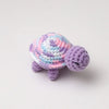 Handmade crocheted turtle plush toy with purple and pink coloring