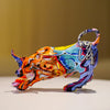 A colorful, stylized animal sculpture with horns and a curved handle, displayed on a white surface.
