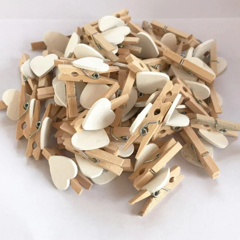 A pile of mini wooden photo clips shaped like hearts for crafts and display