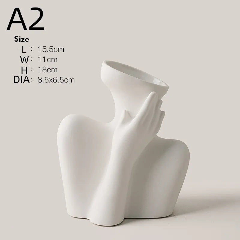 A white ceramic figural vase shaped like an artistic human form, shown from the side.