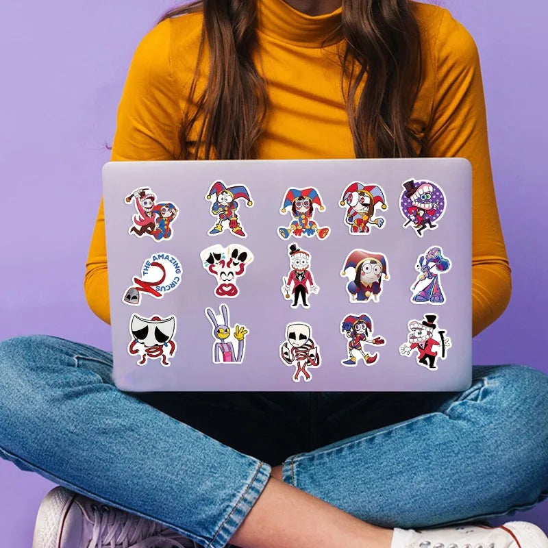 A laptop displaying a set of digital circus themed stickers on a purple background, held by a person wearing a yellow top and