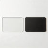 A pair of black and clear acrylic magnetic photo holders, one white and one black.