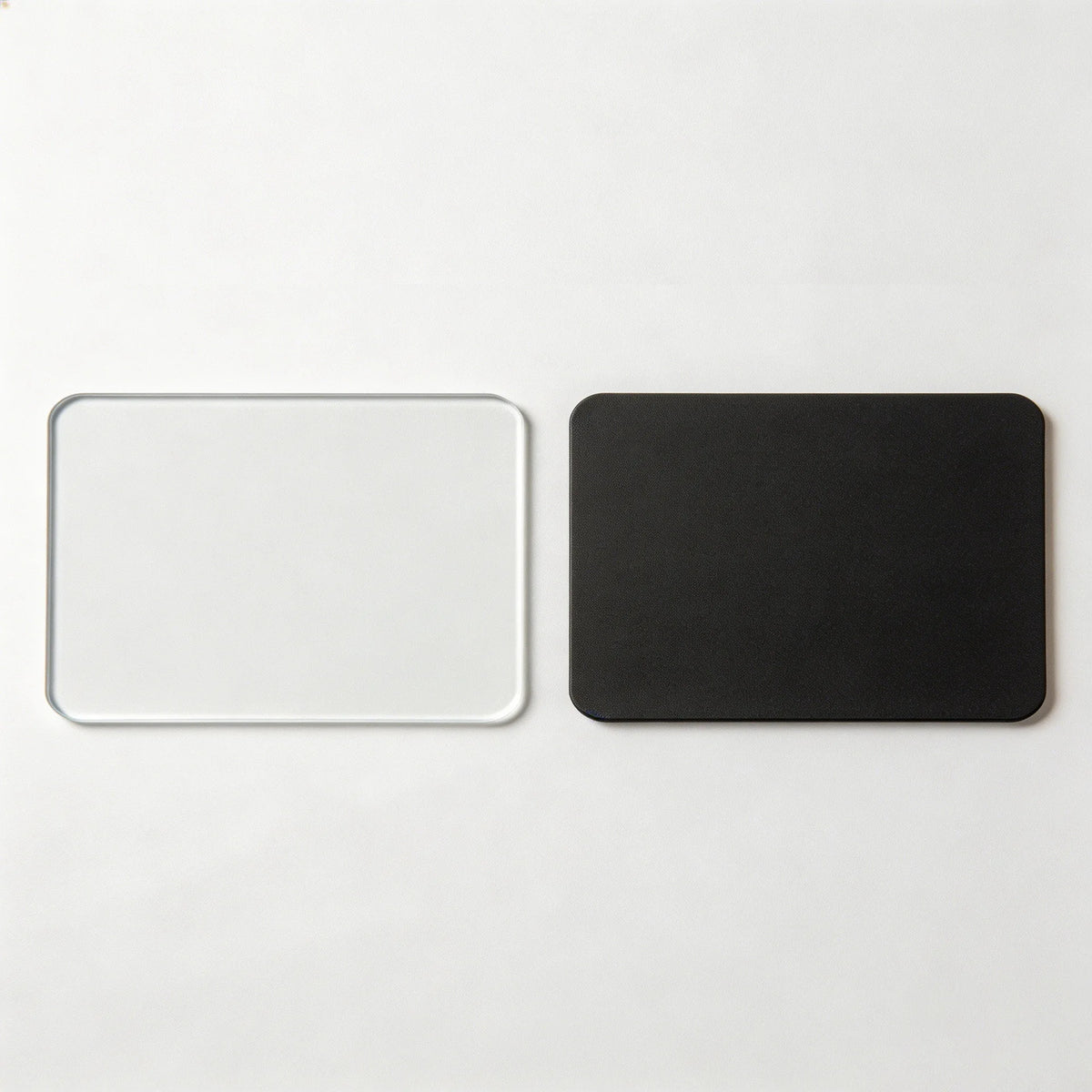 A pair of black and clear acrylic magnetic photo holders, one white and one black.