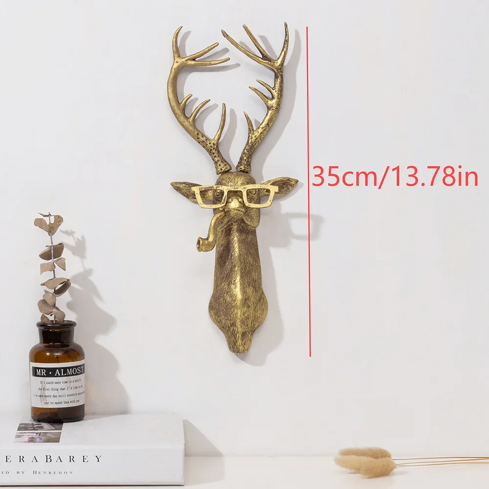 A brass deer head storage hook wall decor featuring antlers and glasses mounted on a white wall.