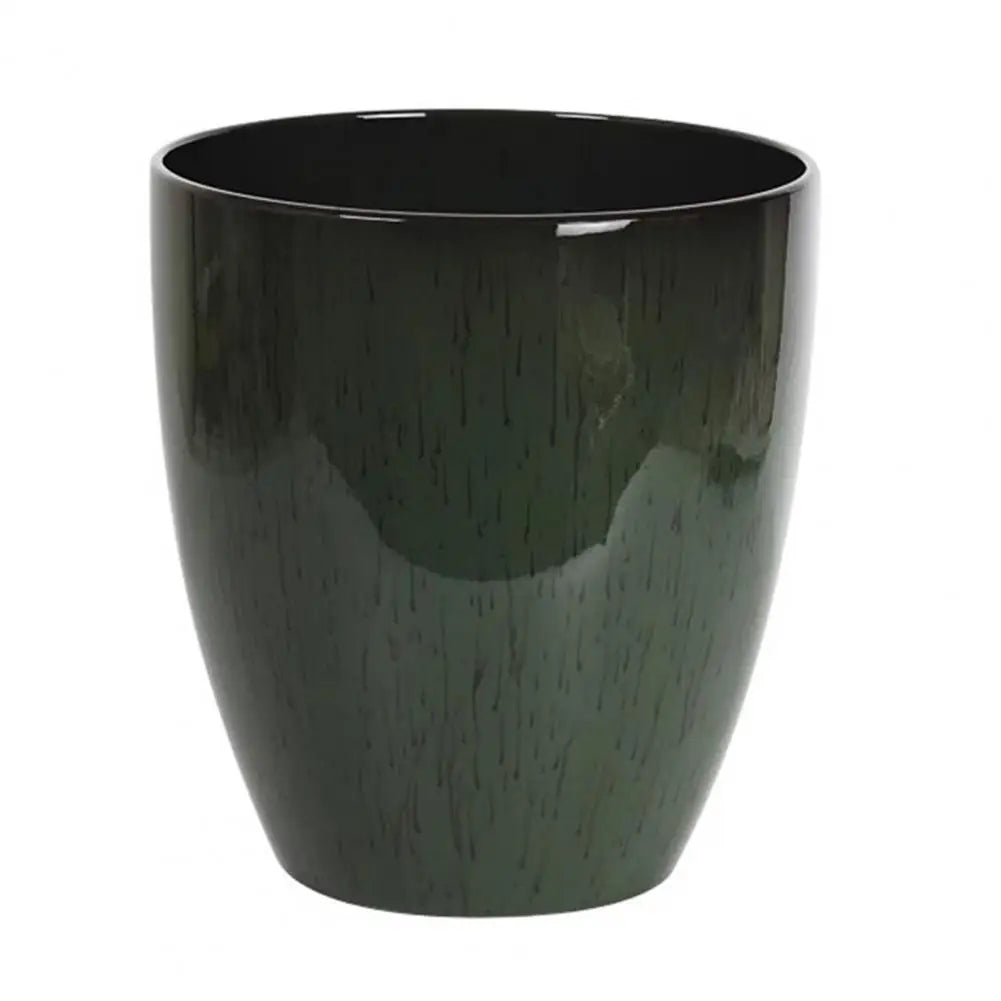 A dark green, glossy resin Monstera plant pot with a saucer.