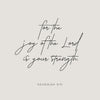 A minimalist design featuring the Bible verse for the joy of the Lord being your strength in elegant script on a light gray b