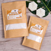 Two brown paper bags of White Beewax product with instructions and wax pieces on a wooden surface.