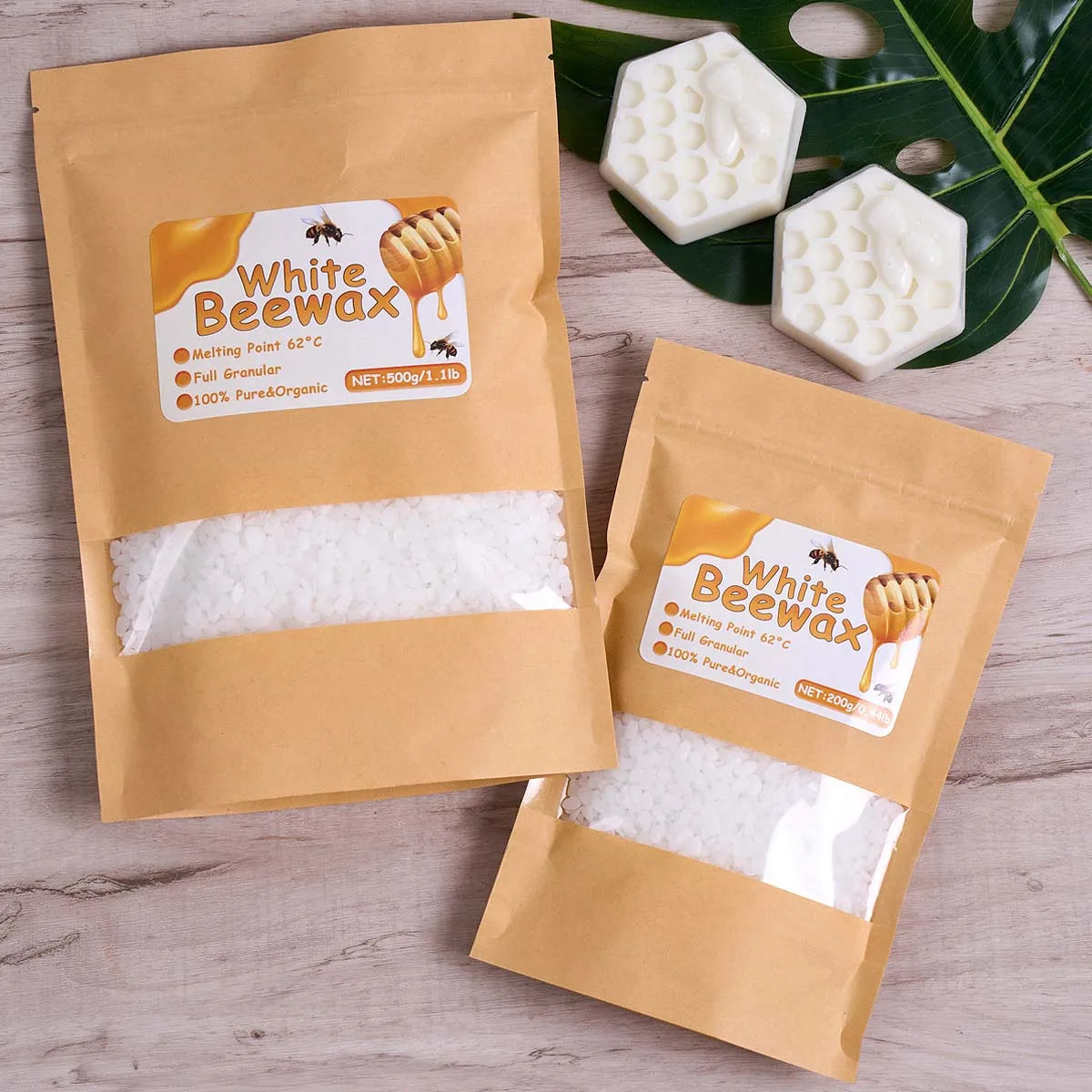 Two brown paper bags of White Beewax product with instructions and wax pieces on a wooden surface.