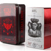 A red metal tin containing an occult tarot deck with a prominent illustration of an emperor figure.