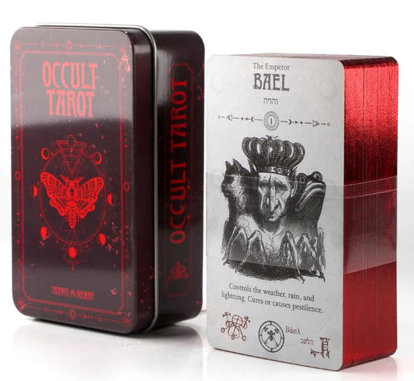A red metal tin containing an occult tarot deck with a prominent illustration of an emperor figure.